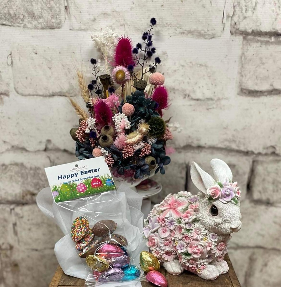 Preserved flower arrangement in a teacup, small ceramic bunny, easter eggs